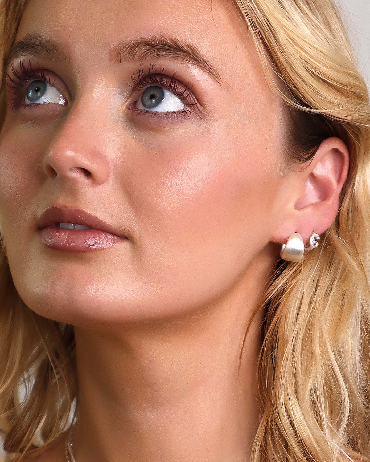 Silver mini hoop earrings styled with other hoops for a layered look