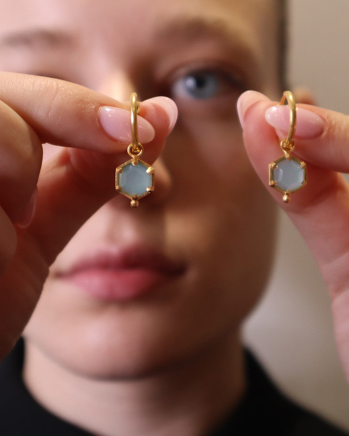 Close-up of gold mini hoop earrings with aqua chalcedony drop charms