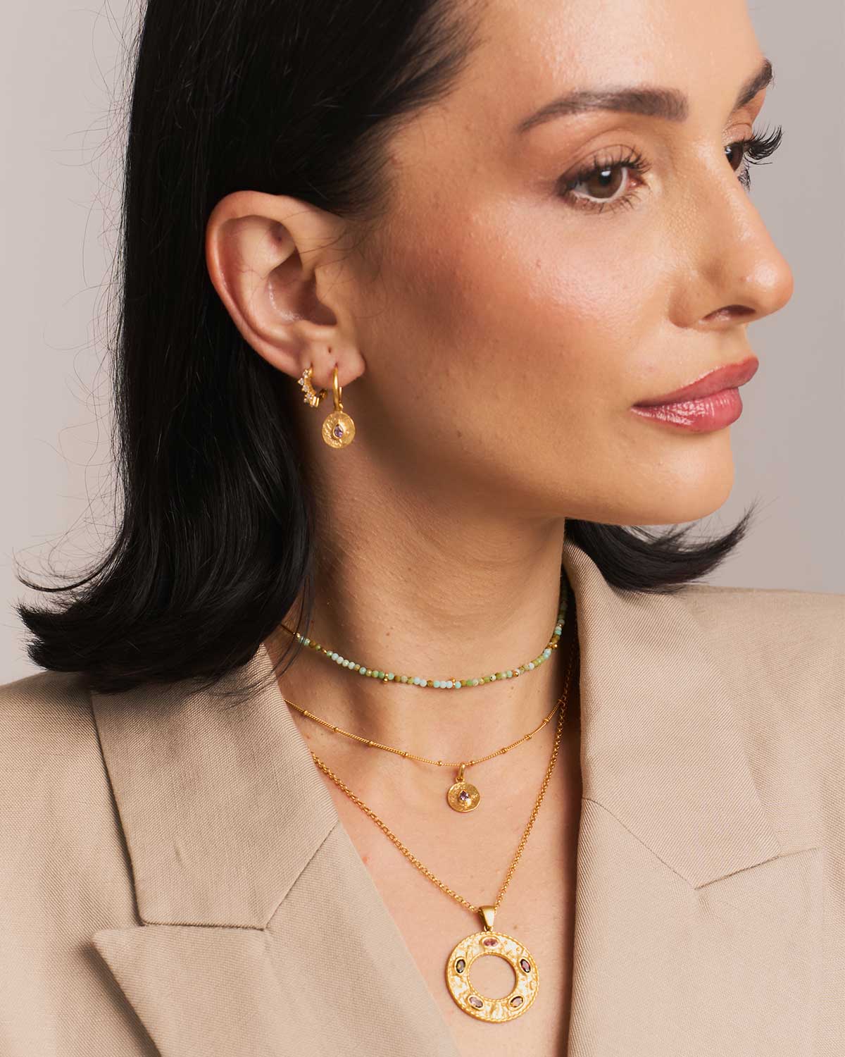 Model wearing mini silver hoops with removable pink amethyst gold disk