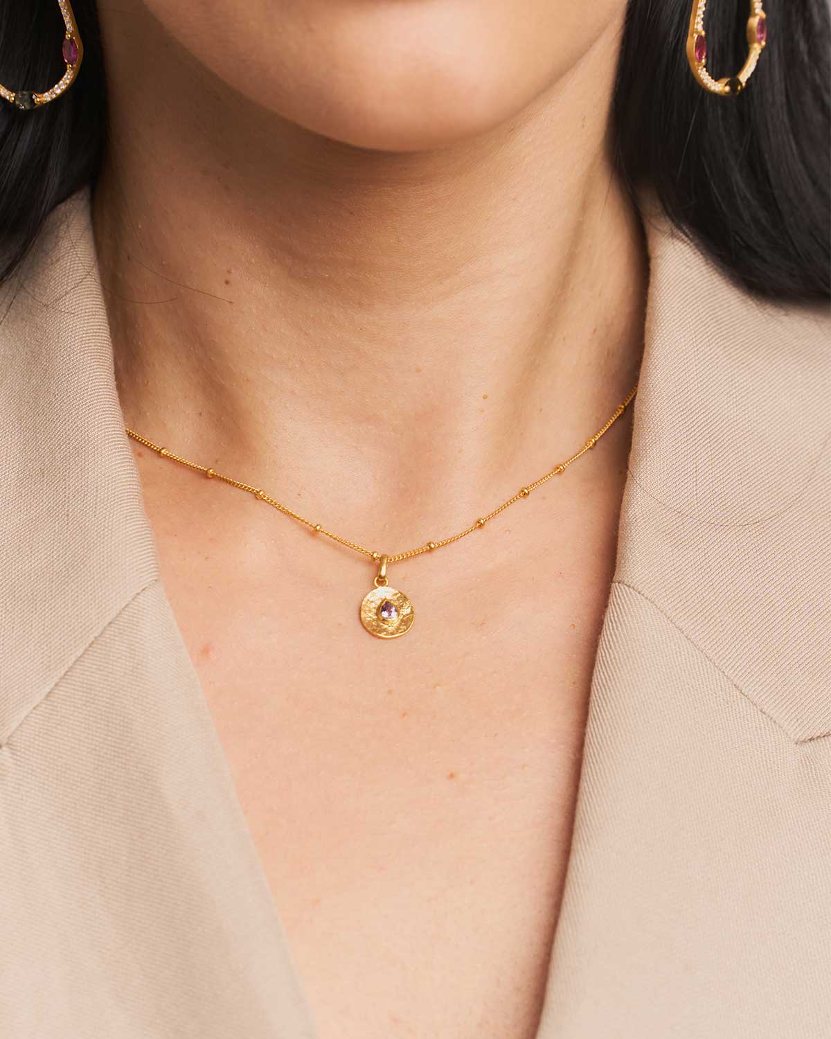 Close-up of silver adjustable necklace featuring a pink amethyst pendant, February's birthstone