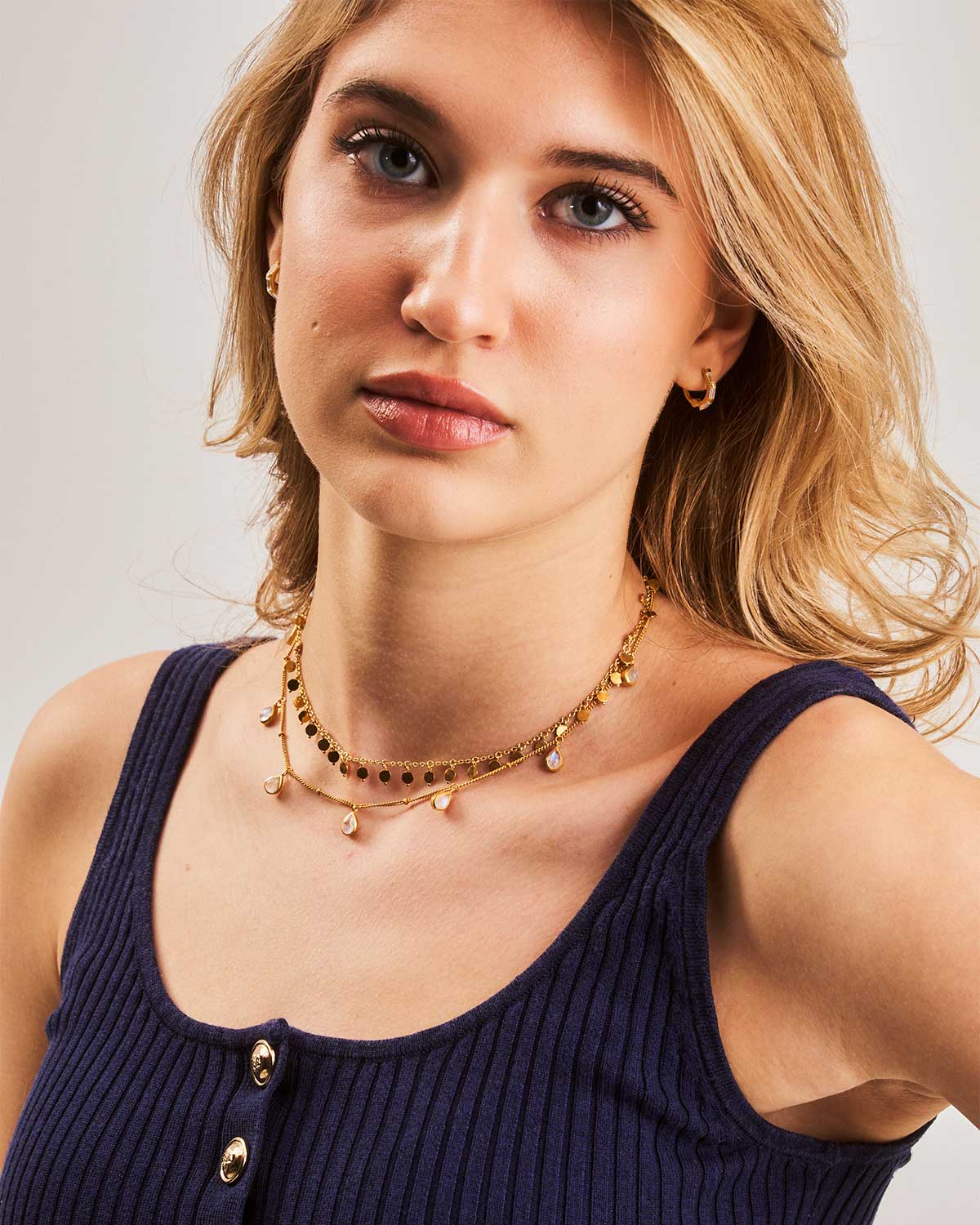 Front view of model wearing an adjustable gold necklace with a natural teardrop moonstone pendant