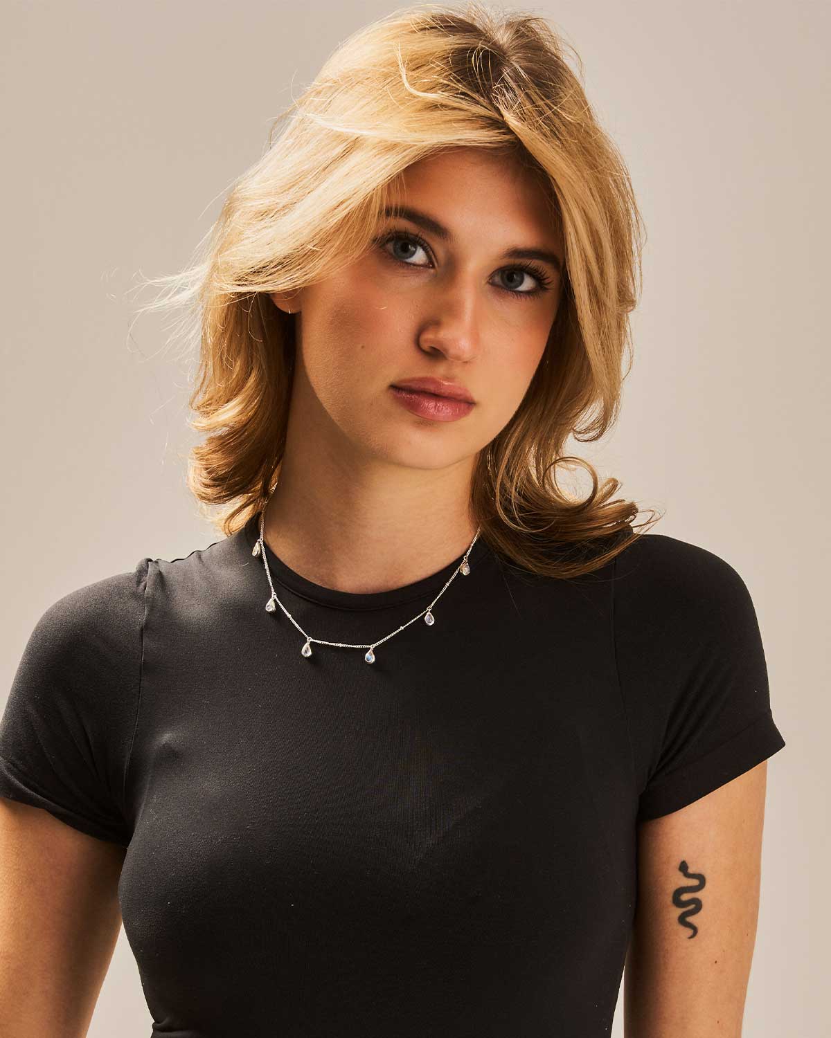 Model wearing adjustable silver necklace with hand-cut rainbow moonstone teardrop pendant