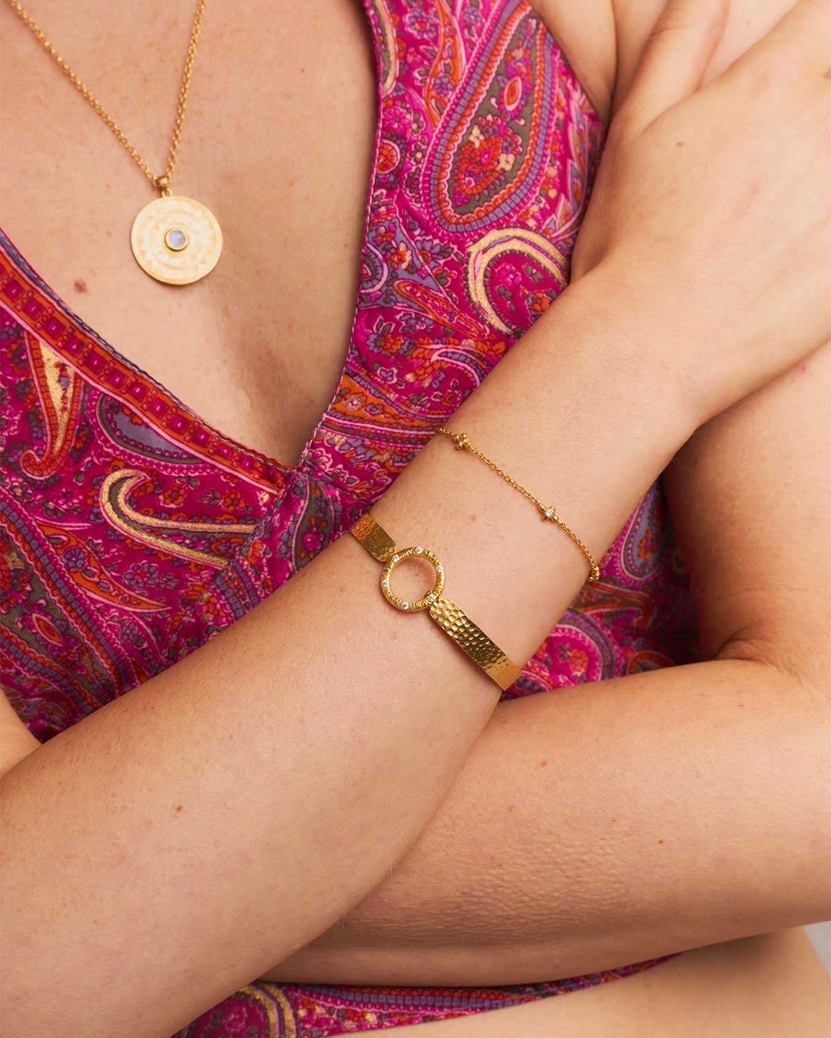 Gold flexible bangle with natural emerald gemstones and a hammered finish