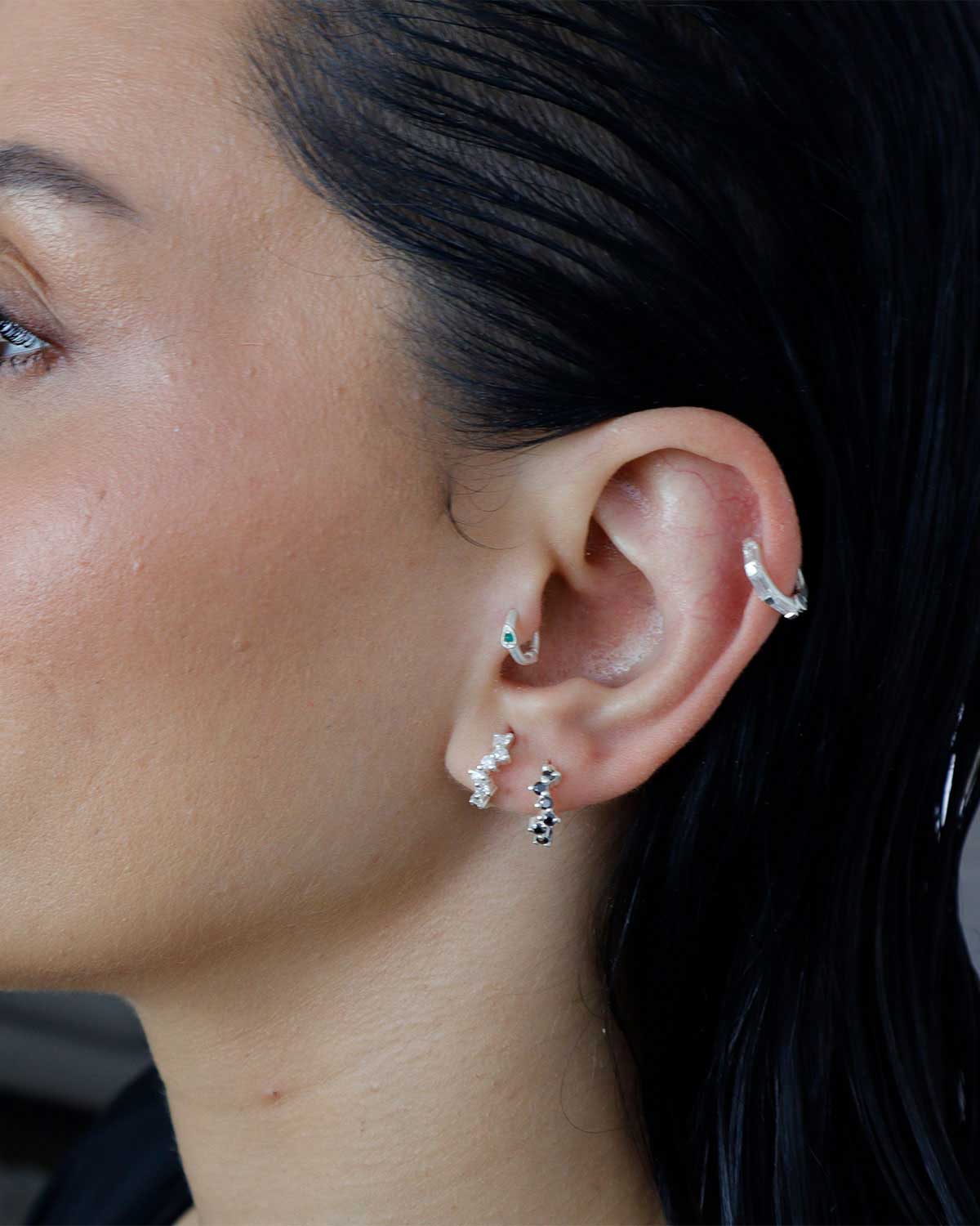 Close-up of an ear with multiple diamond mini hoops