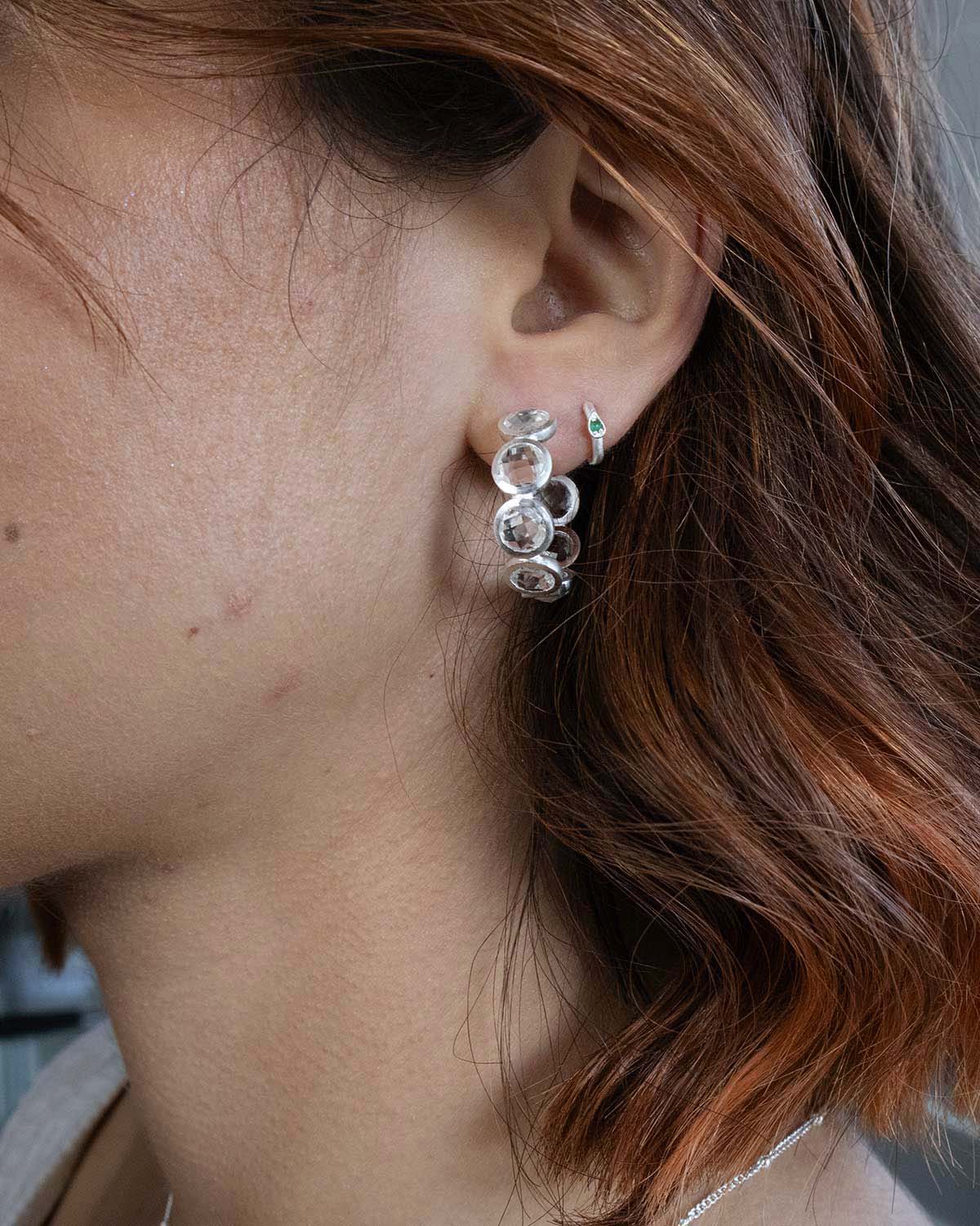 Close-up of crystal silver hoop earrings with a refined polished surface