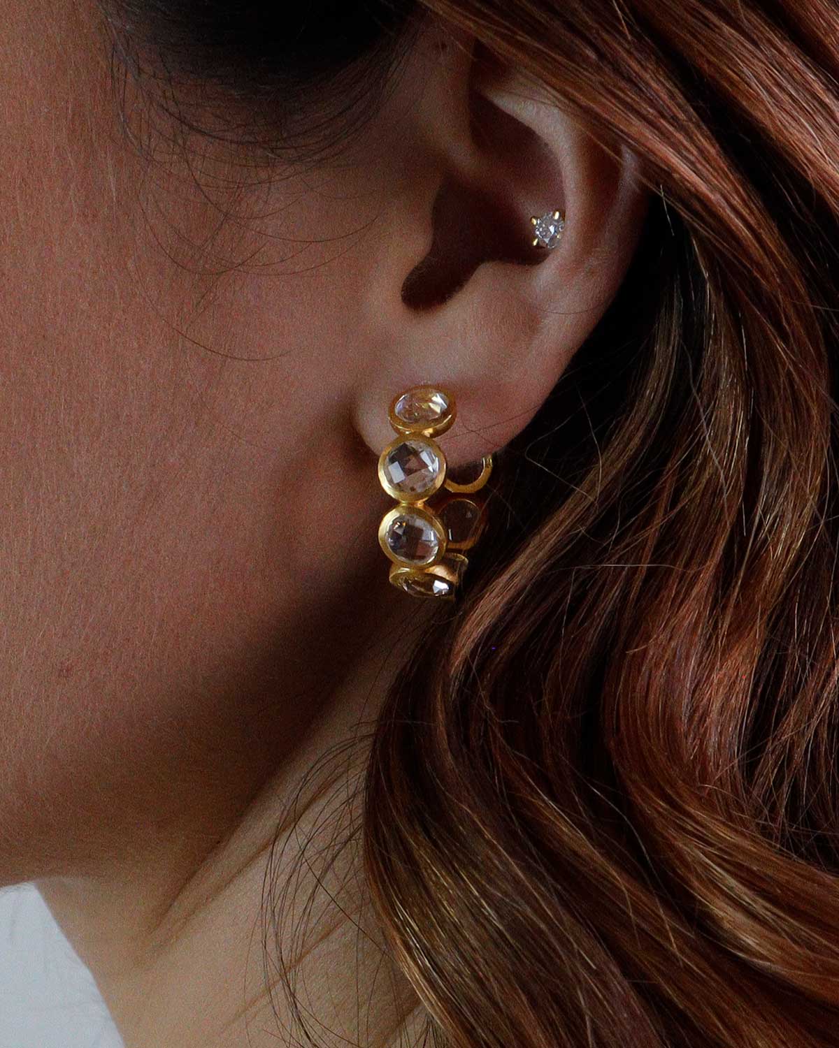 Close-up of gold hoops with natural crystal gemstone detailing