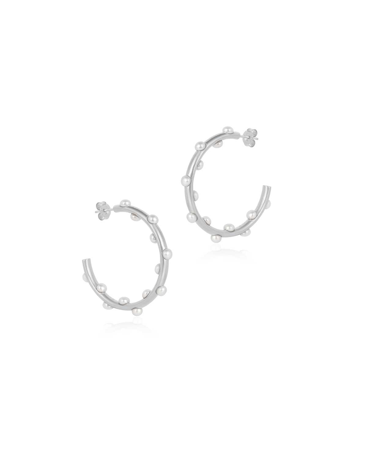 Bold sterling silver hoops adorned with natural pearls, perfect for an elegant statement