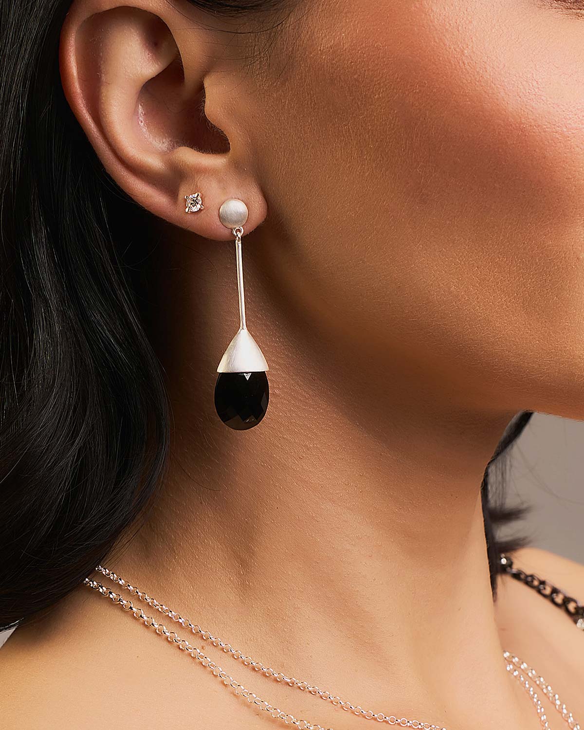 Close-up of black spinel gemstone drop earrings with baguette cut stones