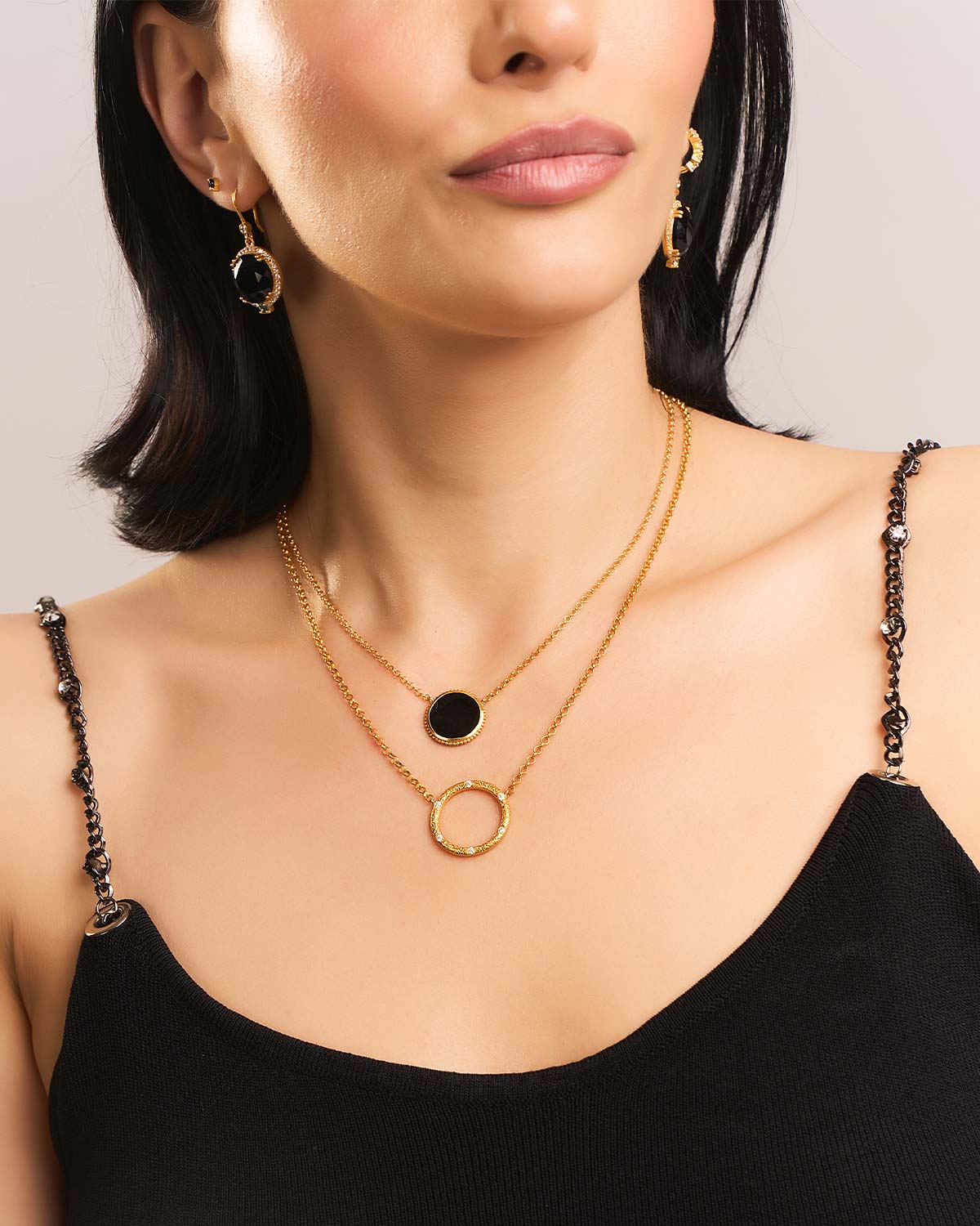 Gold necklace with black spinel pendant styled with other layered necklace