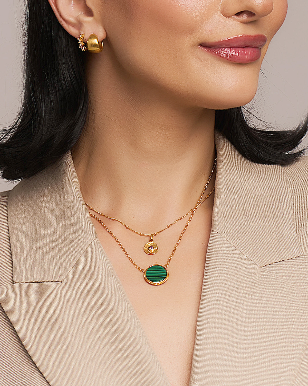 Model wearing gold necklace with natural lash green malachite gemstone