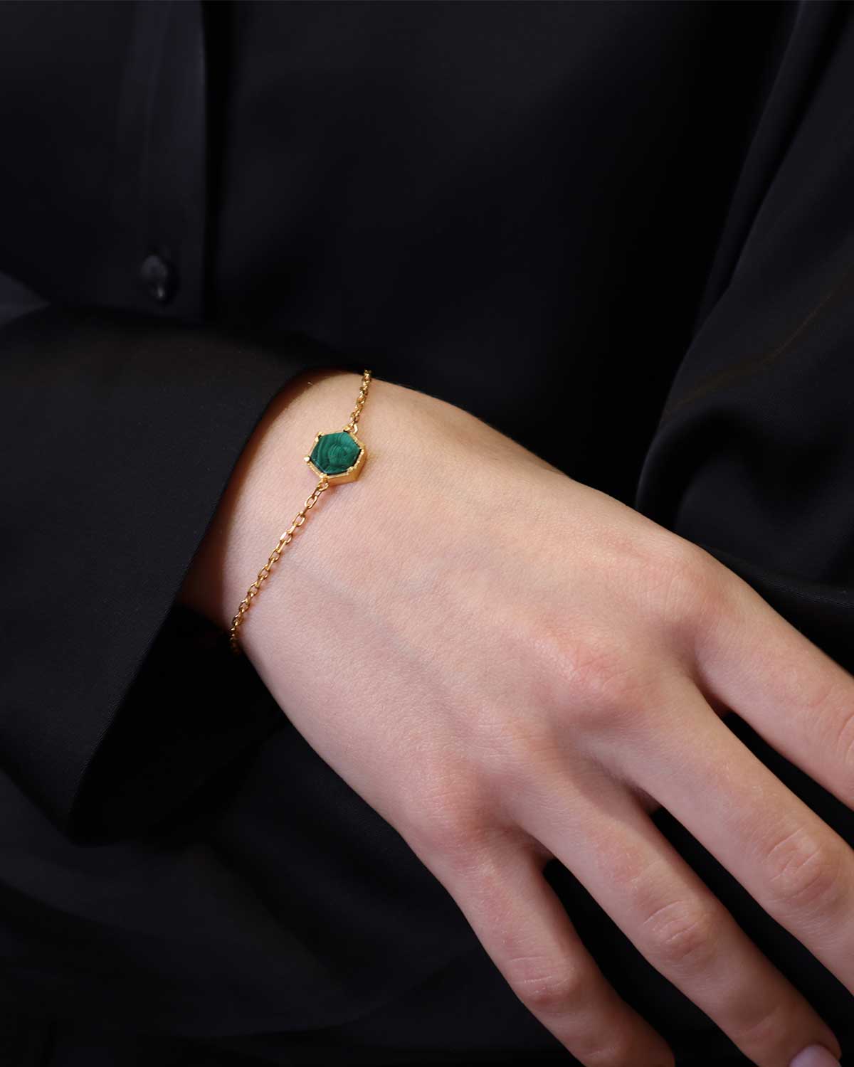 Front view of a gold and silver bracelet with a green malachite gemstone