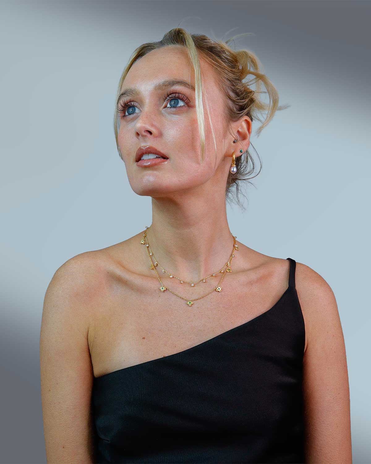 Model wearing handcrafted gold drop earrings with natural pearls