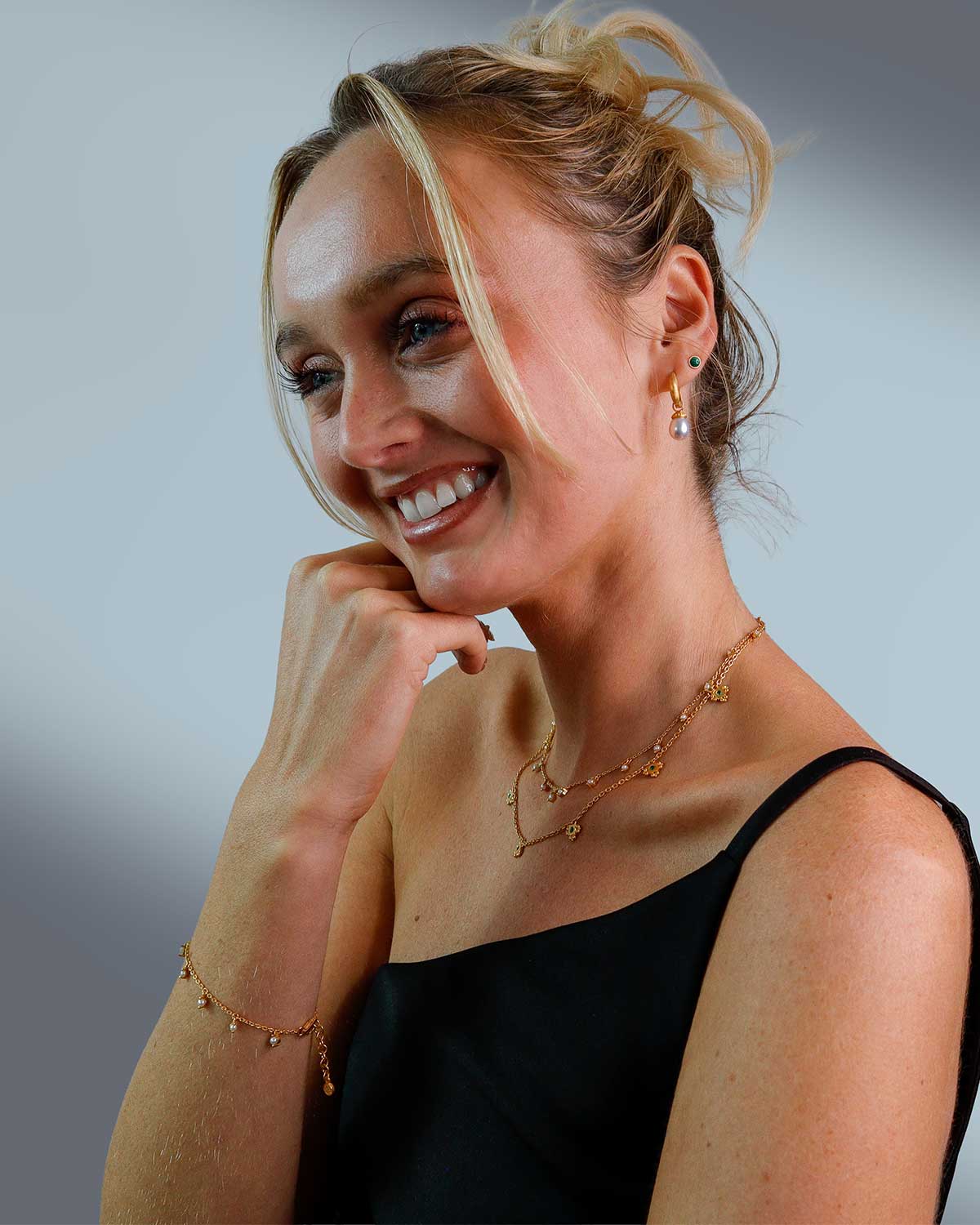 Model wearing gold necklace with graduated pearls