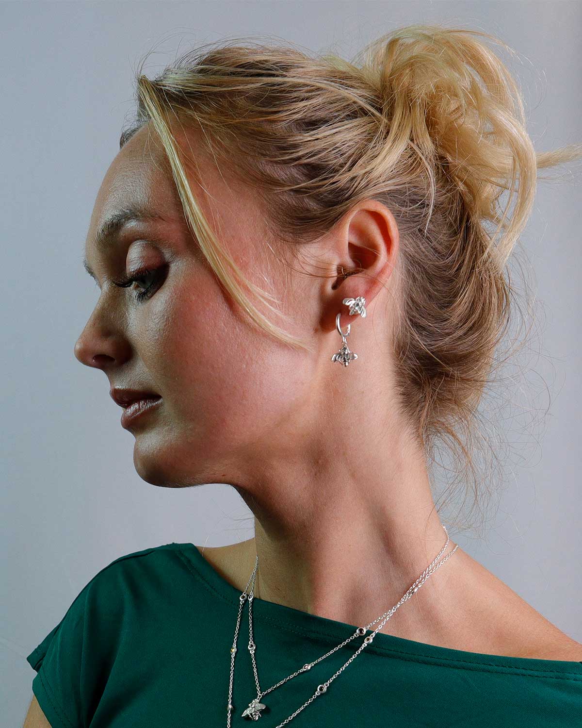 Side view of silver mini hoops highlighting the intricate bee design