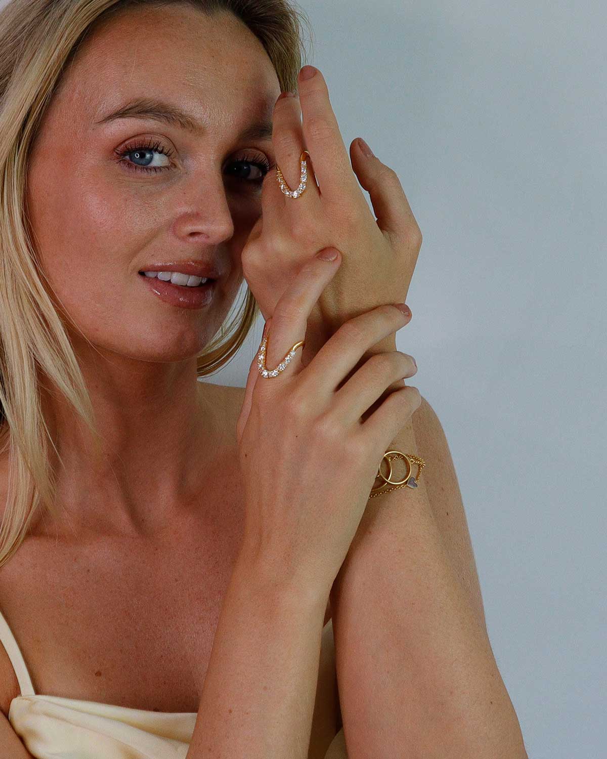 Model wearing gold ring with moissanite diamonds, styled in multiple directions