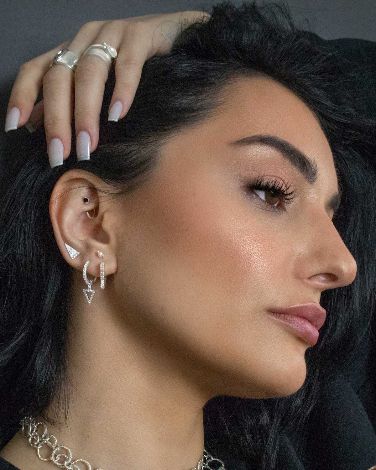 Model wearing silver mini hoop earrings with cubic zirconia crystals