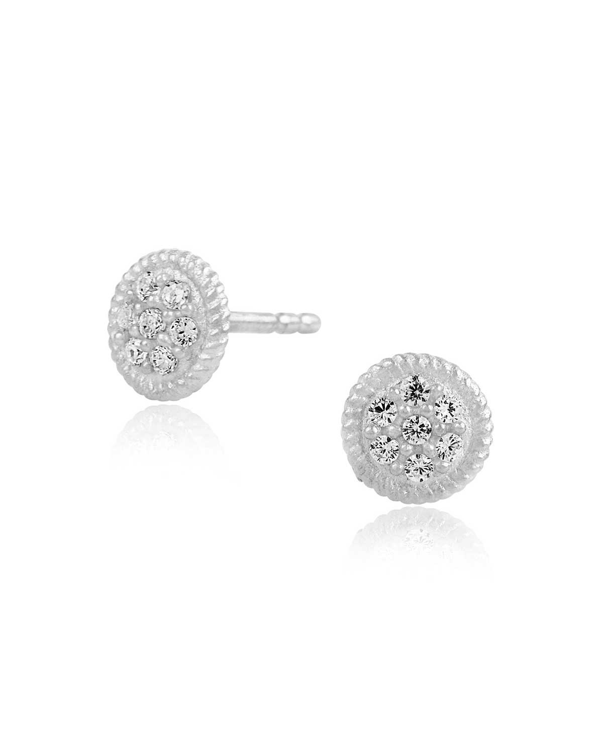 Tiny circular silver ear studs with a sparkly matte finish
