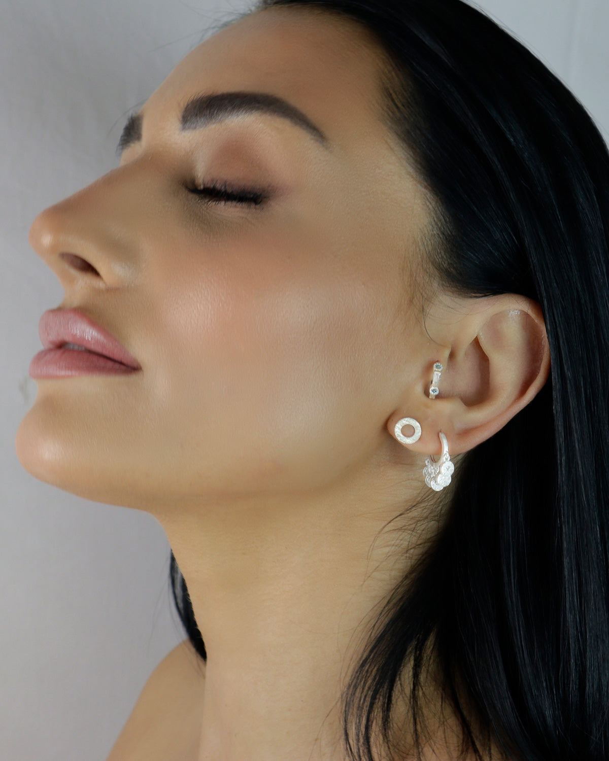 Model wearing silver mini hoop earrings with crystal charms
