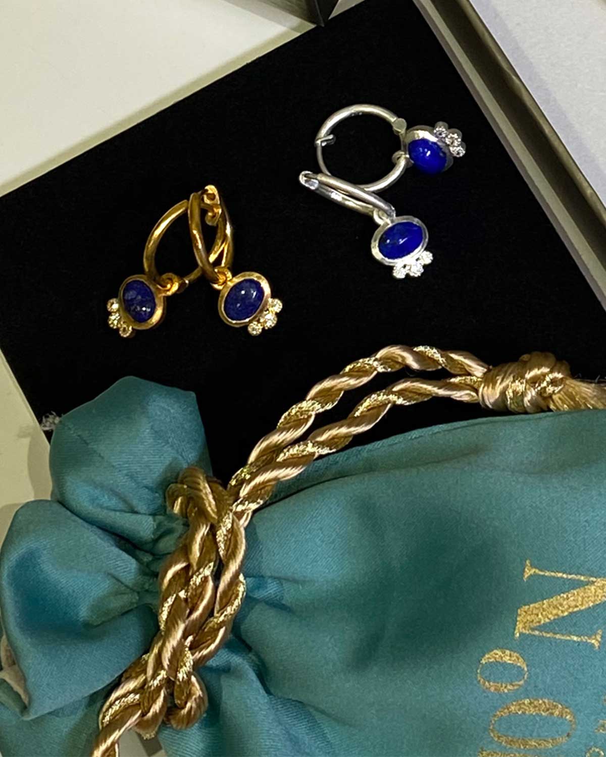 Detail of three tiny crystals below lapis lazuli charm on silver hoops