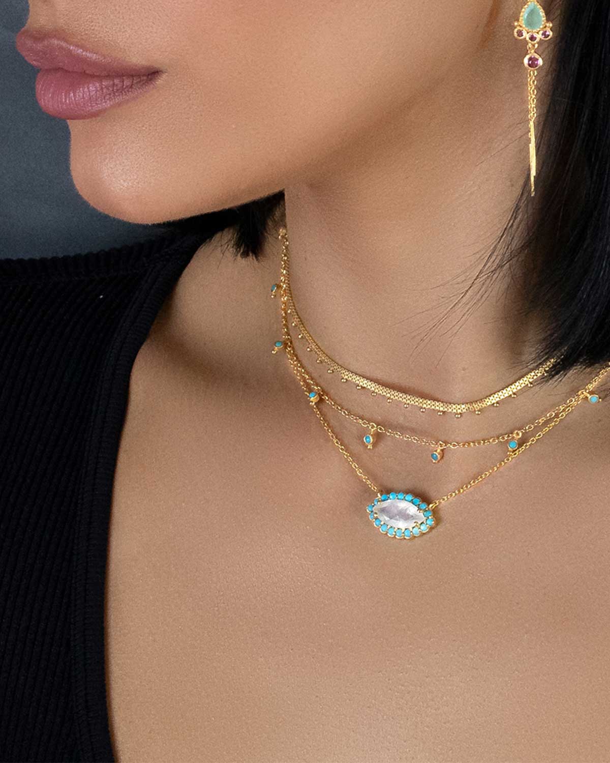 Model wearing silver gemstone eye necklace with turquoise and moonstone