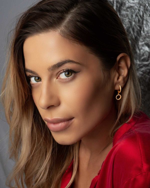 Model wearing silver mini hoop earrings with a subtle shimmer finish