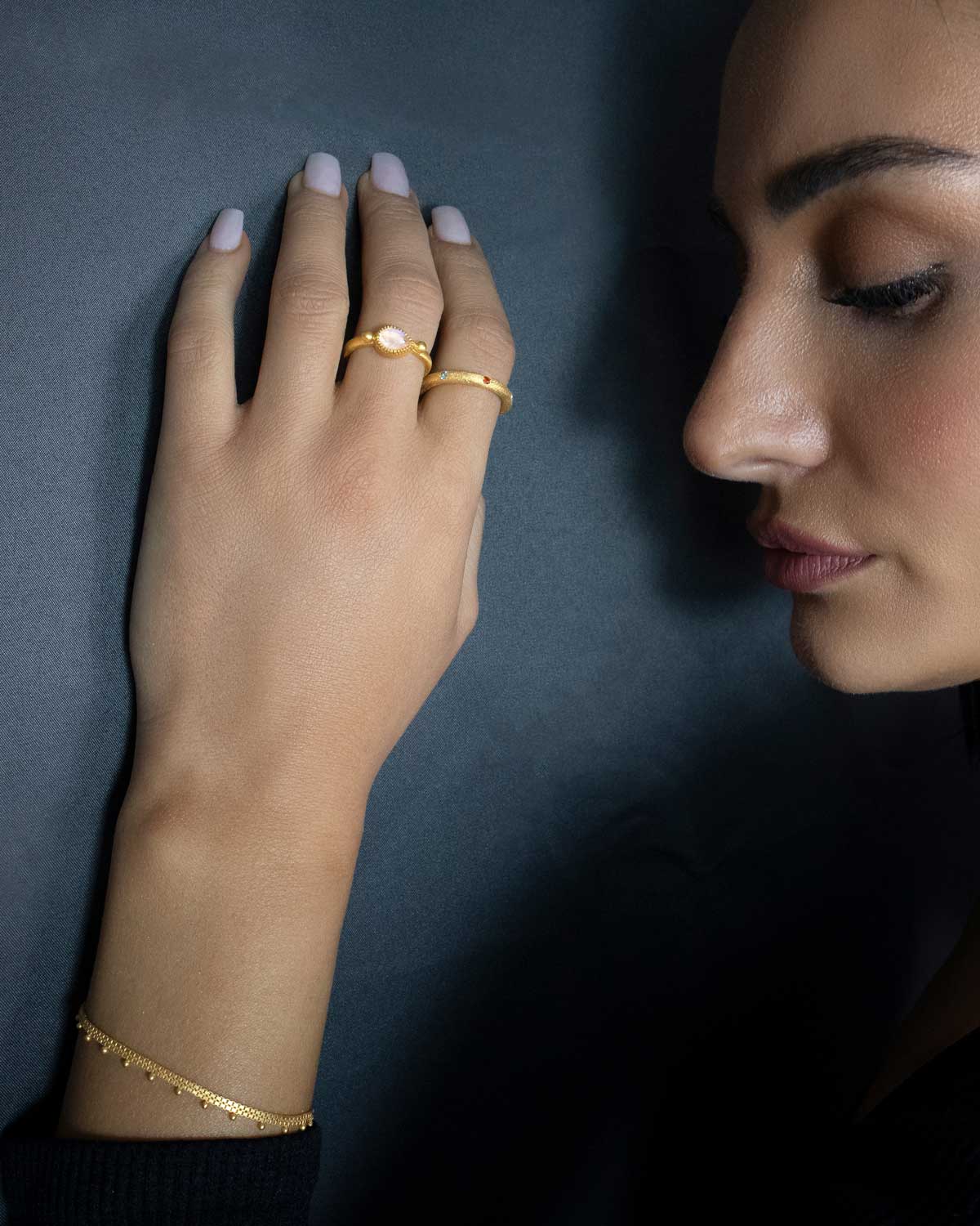 Close-up of gold ring featuring rainbow moonstone gemstone