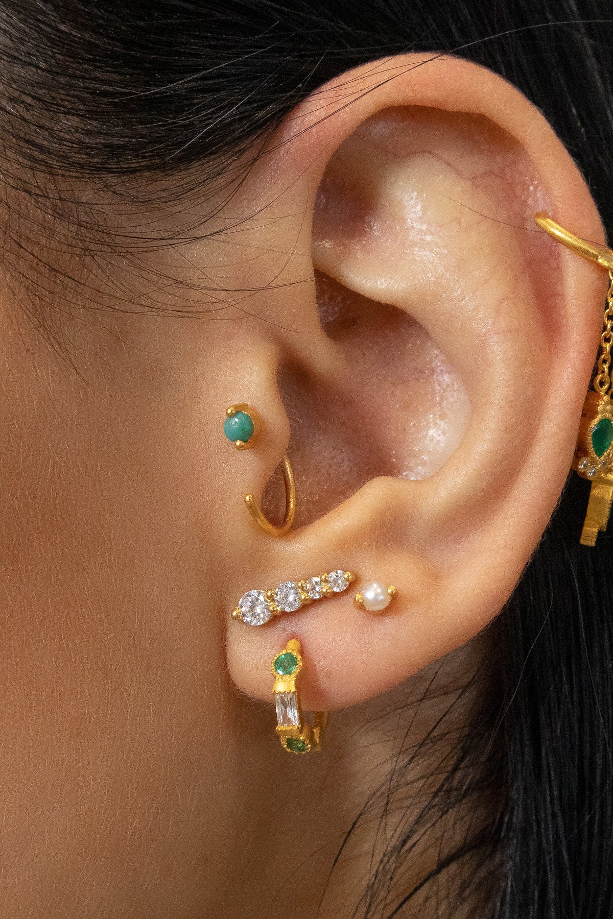 side angle of gold mini hoops with blue topaz and cubic zirconia
