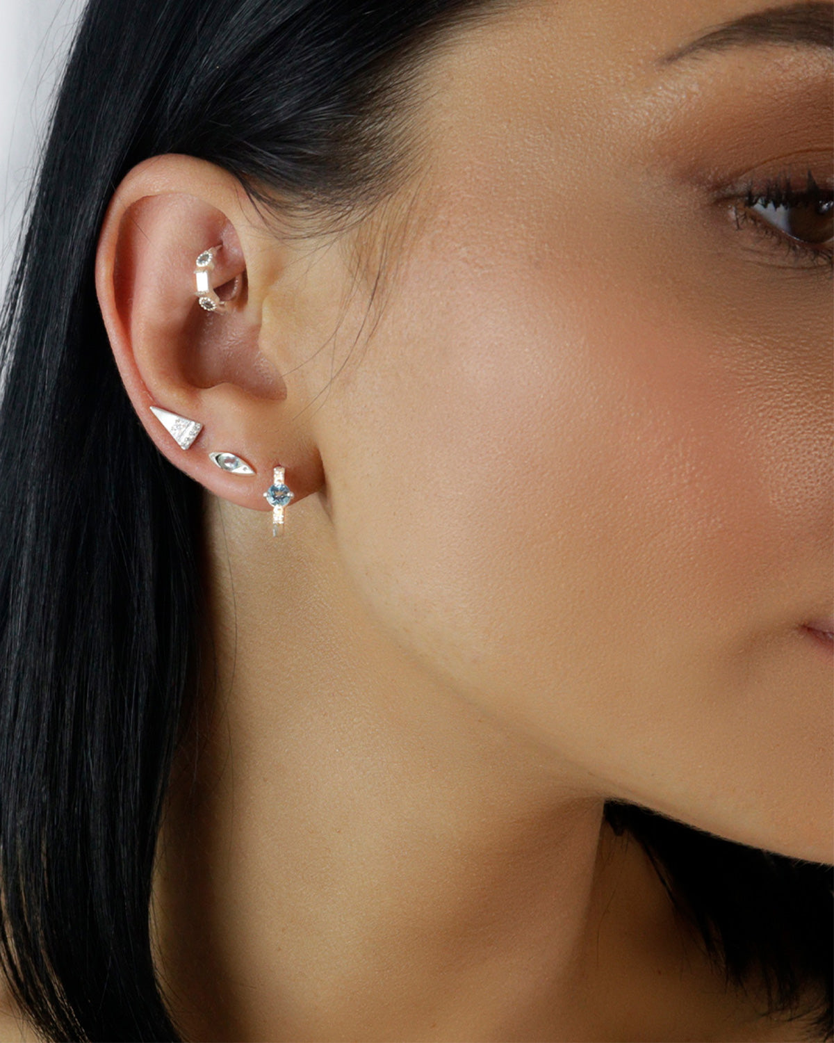 Close-up of silver mini hoops with blue topaz and cubic zirconia