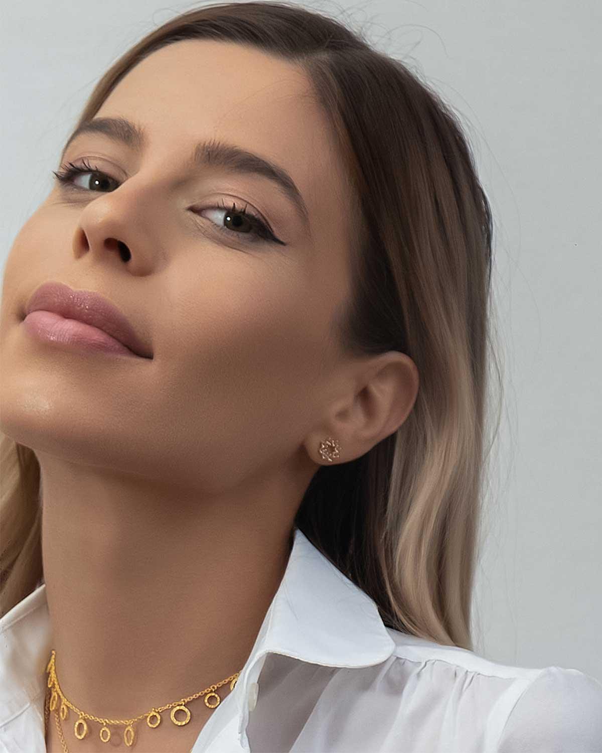 Model wearing tiny blue topaz silver stud earrings