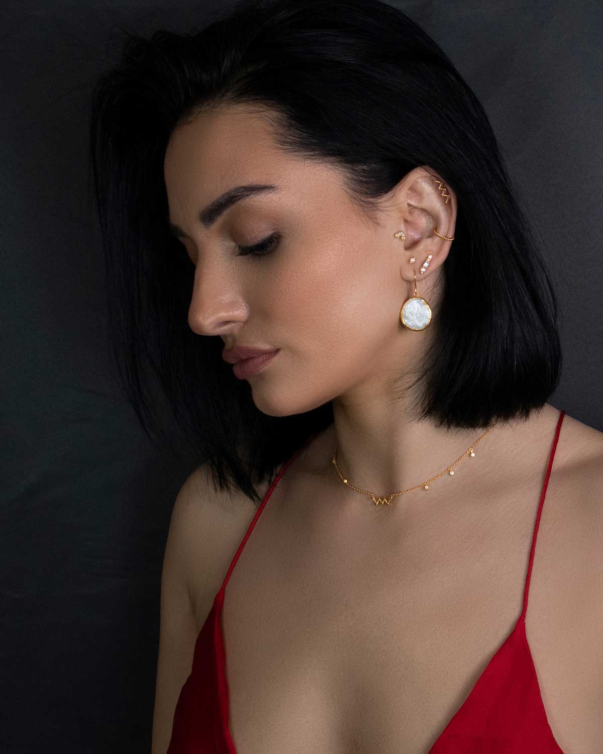 Model wearing gold earrings with natural keshi pearls