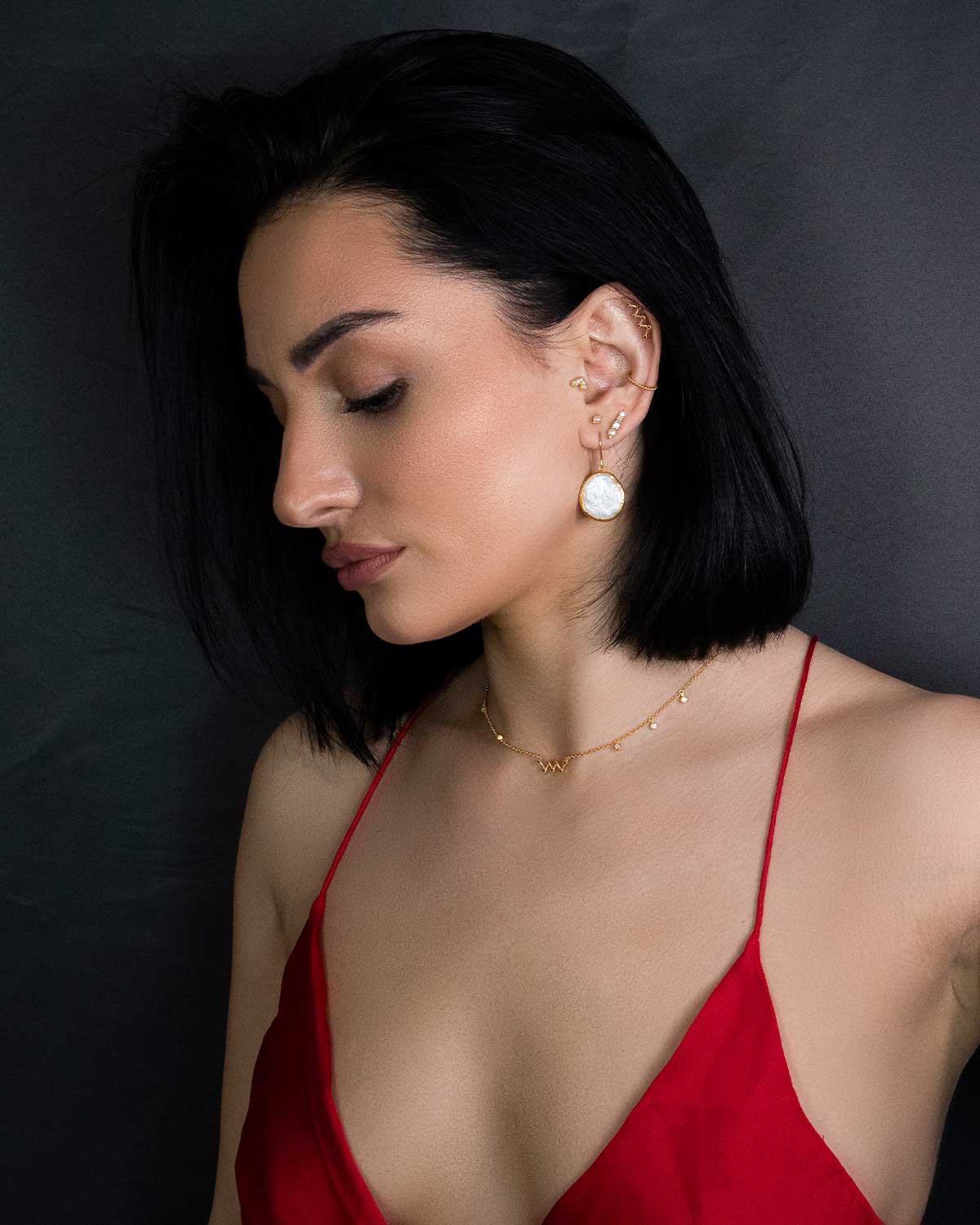 Model wearing gold earrings with natural keshi pearls