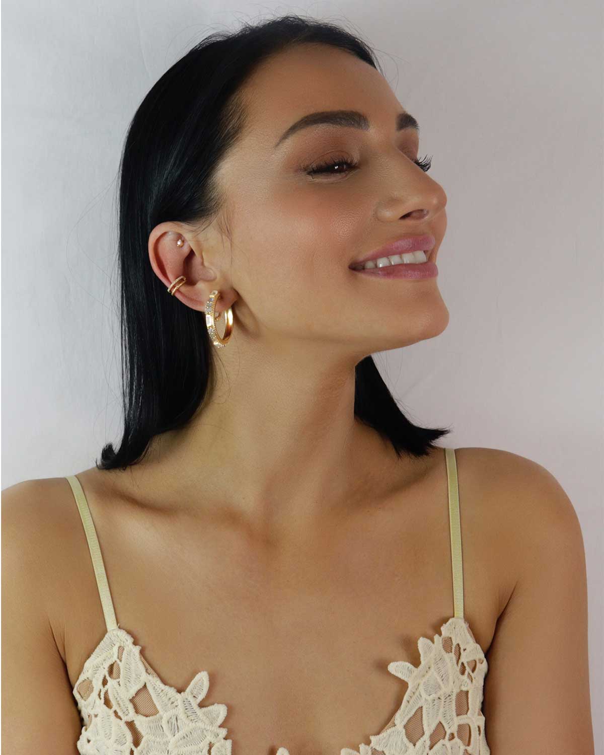 Model wearing gold hoops with rainbow moonstone and labradorite