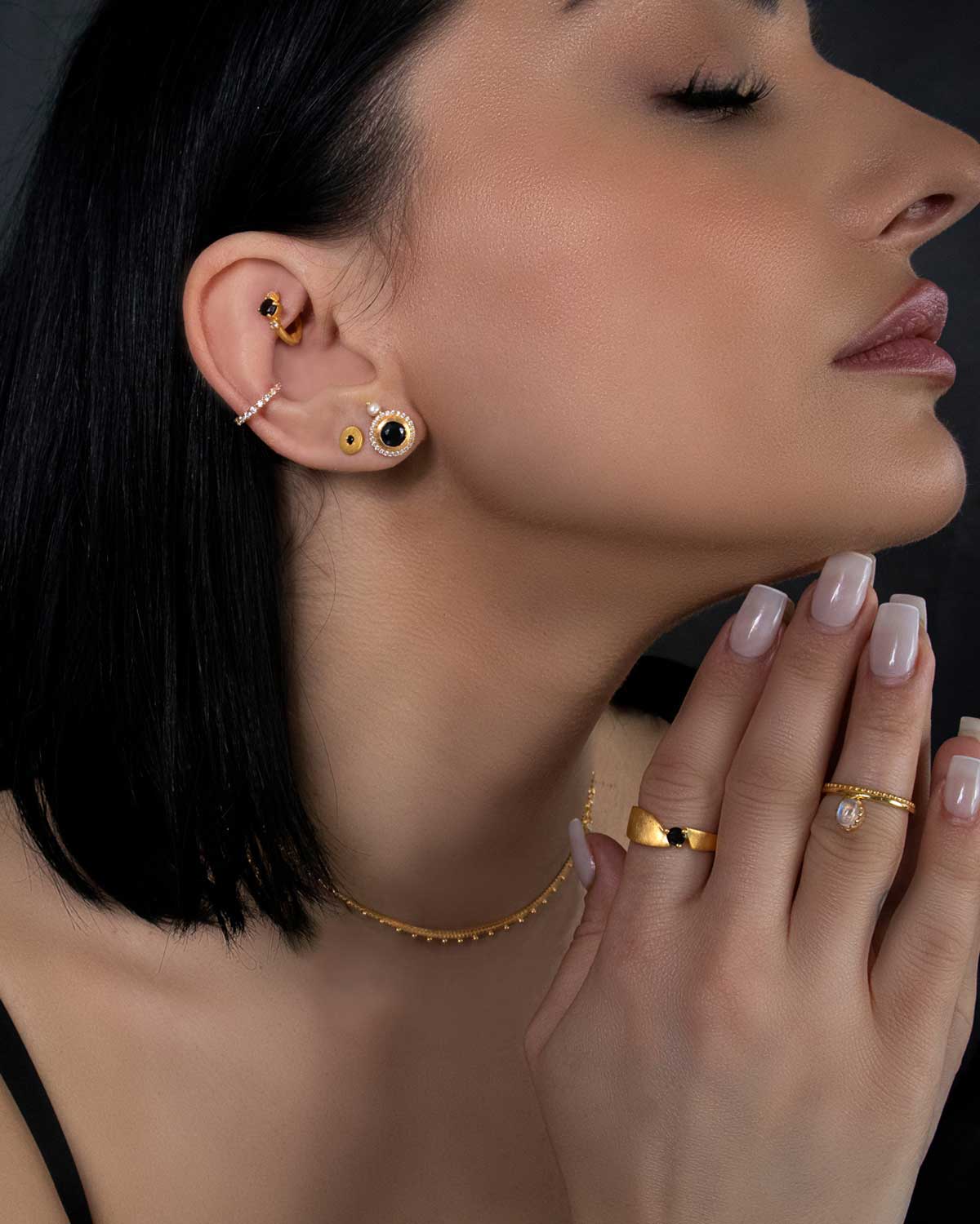 Model wearing gold mini hoops with pink tourmaline gemstones and pearls