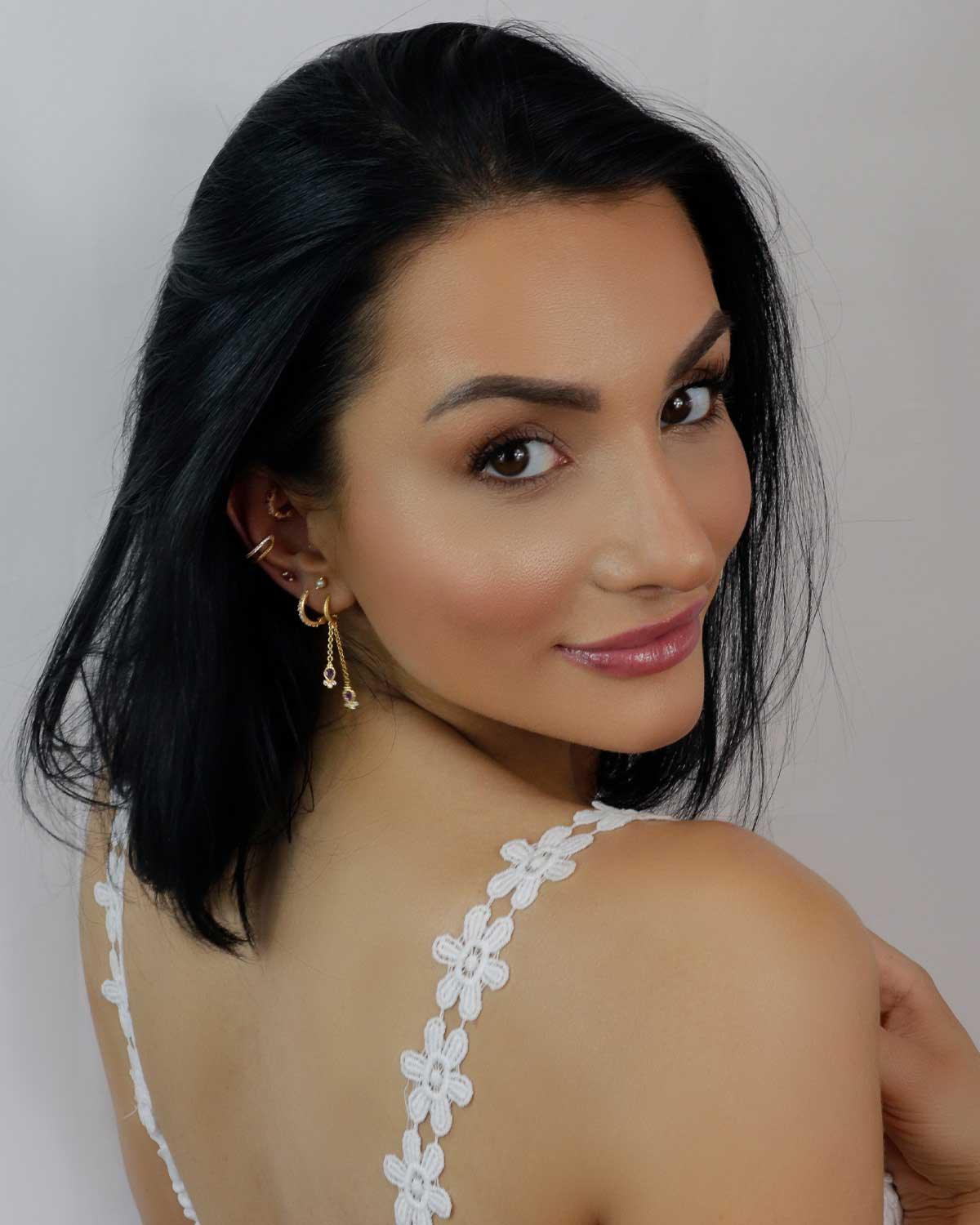 Model wearing gold plated mini hoops with amethyst gemstone drops