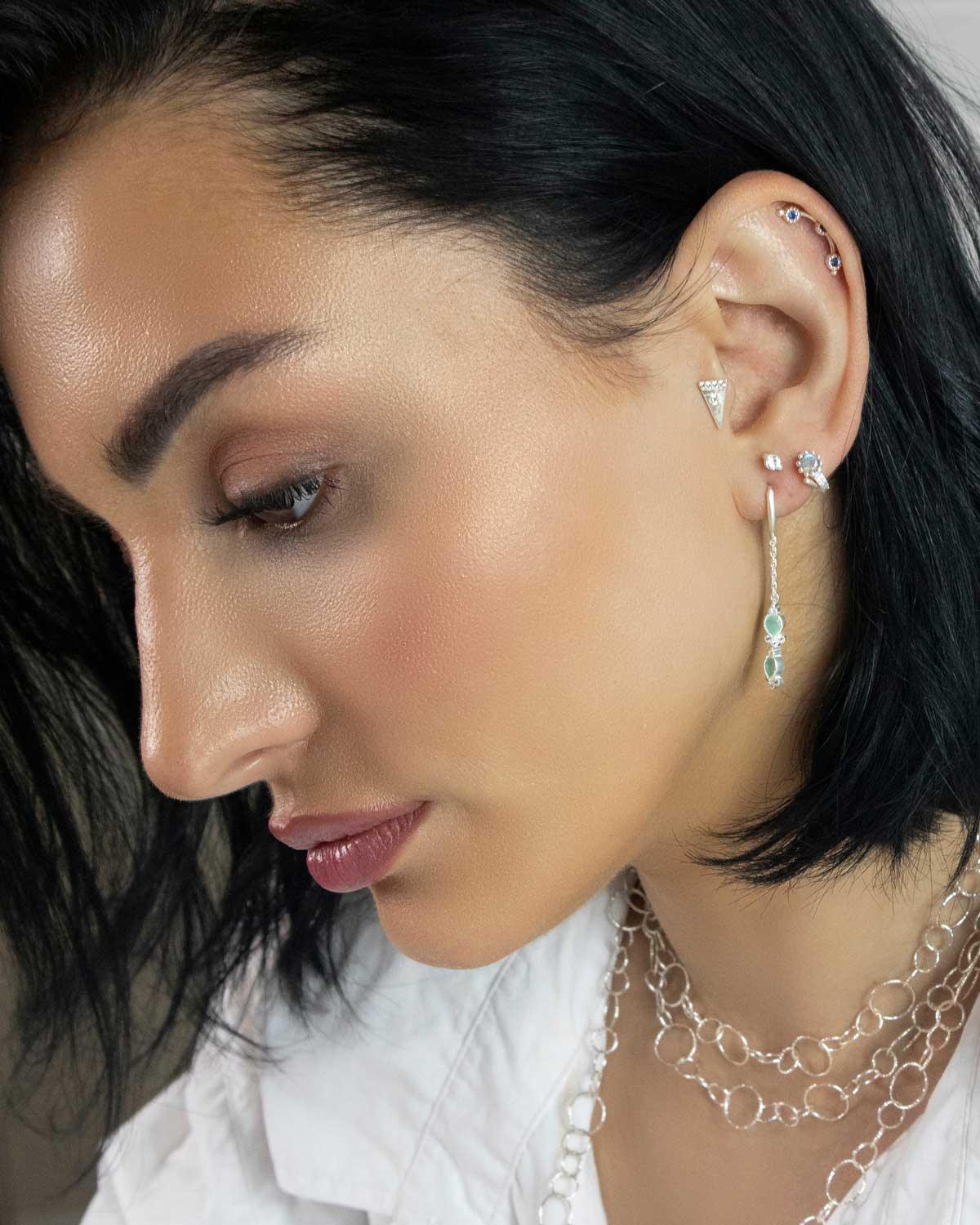 Close-up of mini hoops with aqua chalcedony gemstones and tiny crystal detail