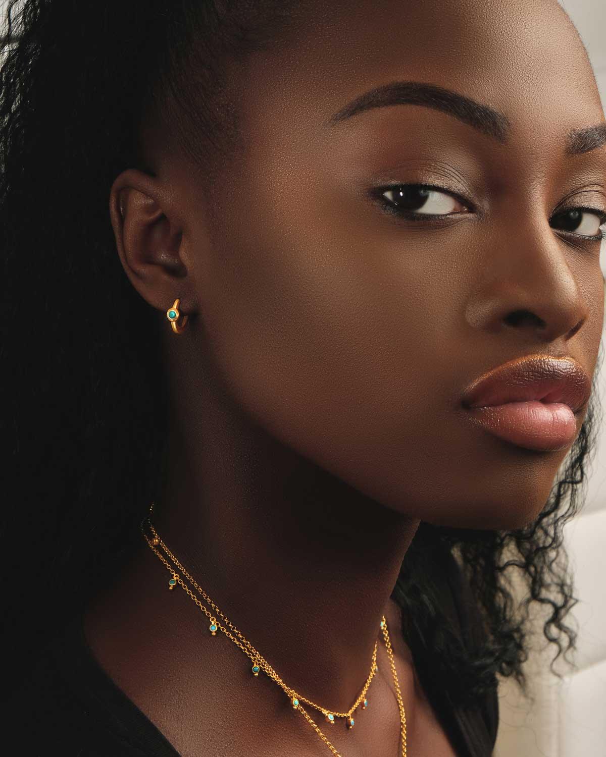 Close-up of hand-cut black spinel gemstones on a gold chain