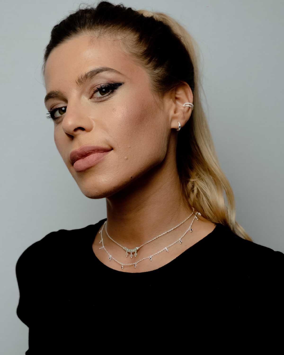 Model wearing silver necklace with tiny amethyst gemstones