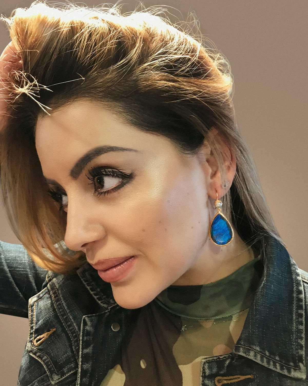 Model wearing teardrop silver earrings with labradorite and pearl